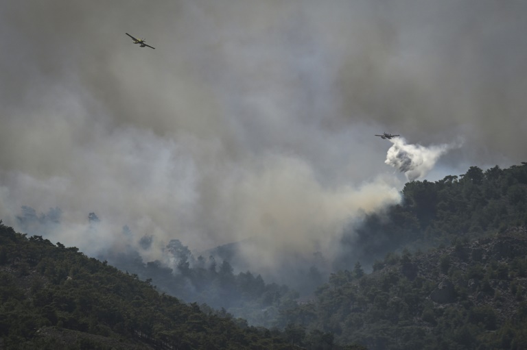 Αεροσκάφη ρίχνουν φορτίο νερού σε δασική πυρκαγιά μεταξύ των χωριών Κιοτάρι και Γεννάδι, στο νησί της Ρόδου, στις 24 Ιουλίου 2023 στην Ελλάδα (AFP - Σπύρος ΜΠΑΚΑΛΗΣ)