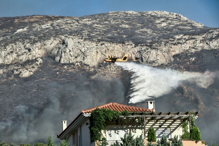 Ένα υδροβομβαρδιστικό εργάζεται στον Κουβαρά κοντά στο Λαγονήσι, περίπου 35 χιλιόμετρα από την Αθήνα, στις 17 Ιουλίου 2023 (AFP - Σπύρος ΜΠΑΚΑΛΗΣ)