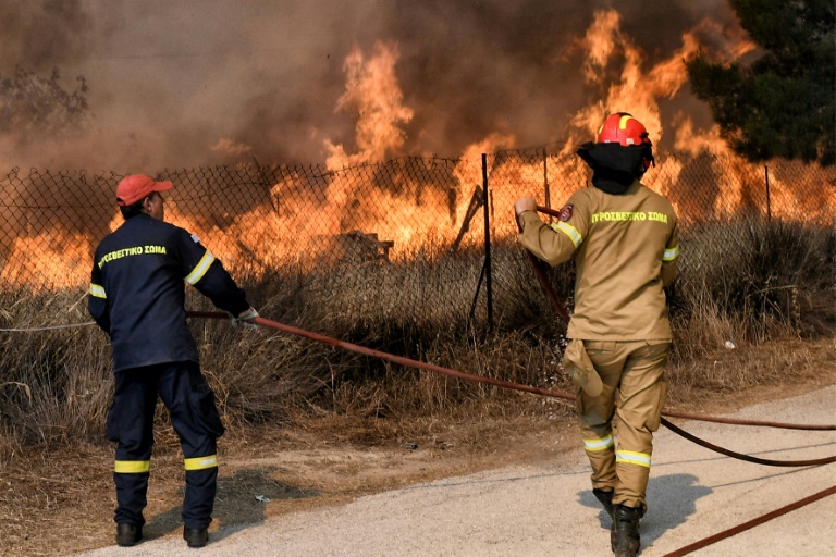 Πυροσβέστες δίνουν μάχη με δασική πυρκαγιά στην Ειρήνη, κοντά στο Λουτράκι, στις 17 Ιουλίου 2023 στην Ελλάδα (AFP - Valerie GACHE)