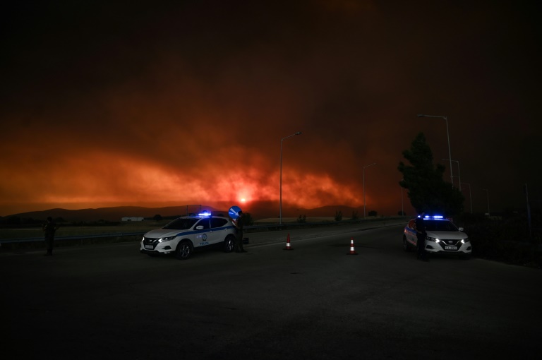 Αστυνομικά οχήματα αποκλείουν δρόμο καθώς μαίνεται δασική πυρκαγιά κοντά στην Αλεξανδρούπολη στις 21 Αυγούστου 2023 στη βόρεια Ελλάδα (AFP - Σάκης Μητρολίδης)