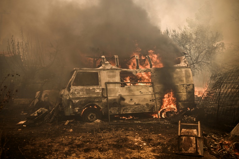 Ένα όχημα στις φλόγες στις Αχαρνές, βόρεια της Αθήνας, στις 23 Αυγούστου 2023 στην Ελλάδα (AFP - Άγγελος Τζωρτζίνης)