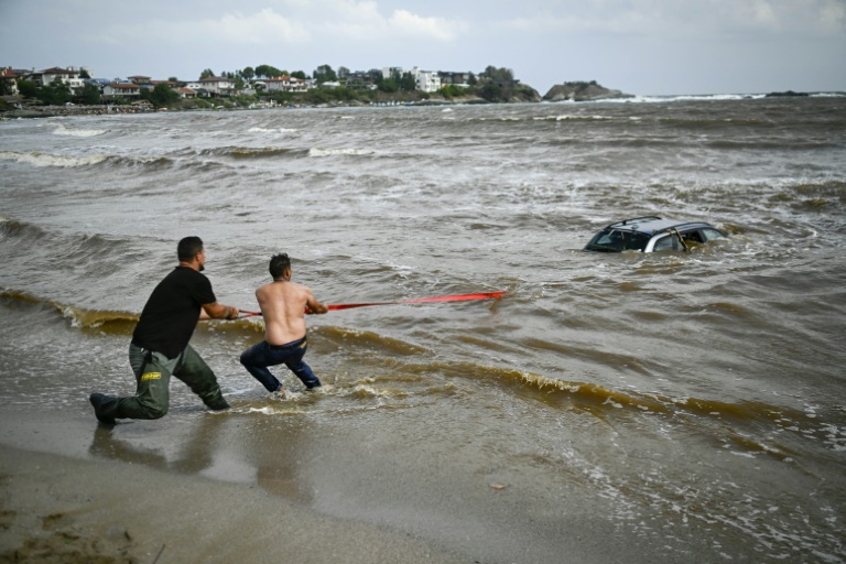 Άνθρωποι προσπαθούν να βγάλουν ένα αυτοκίνητο από τη θάλασσα στον καταυλισμό Arapia κοντά στο Tsarevo στη Βουλγαρία στις 6 Σεπτεμβρίου 2023 (AFP - Nikolay DOYCHINOV)